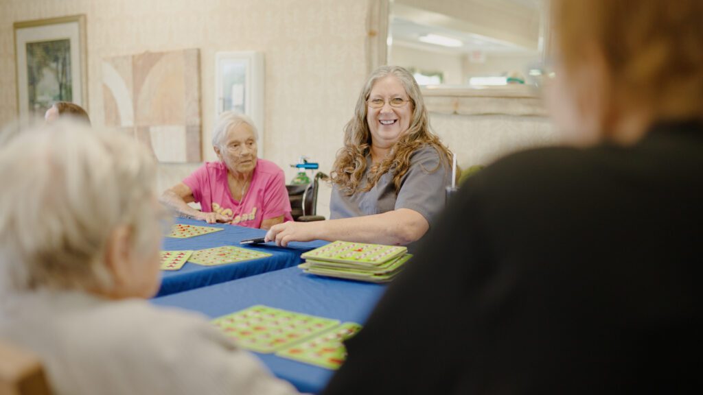 A group of residents playing bingo at a skilled nursing facility